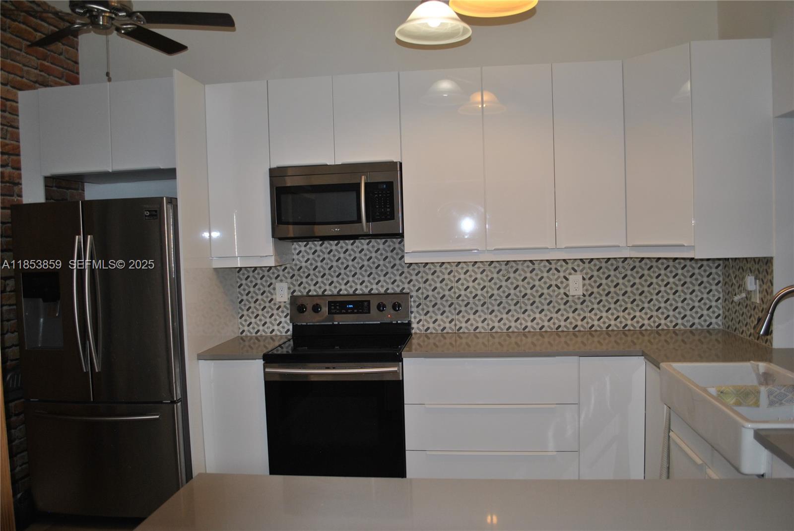 19941 Northeast 5th Court, Unit 3M Miami, FL 33179 - Photo 8 of 25 a kitchen with a refrigerator stove and microwave