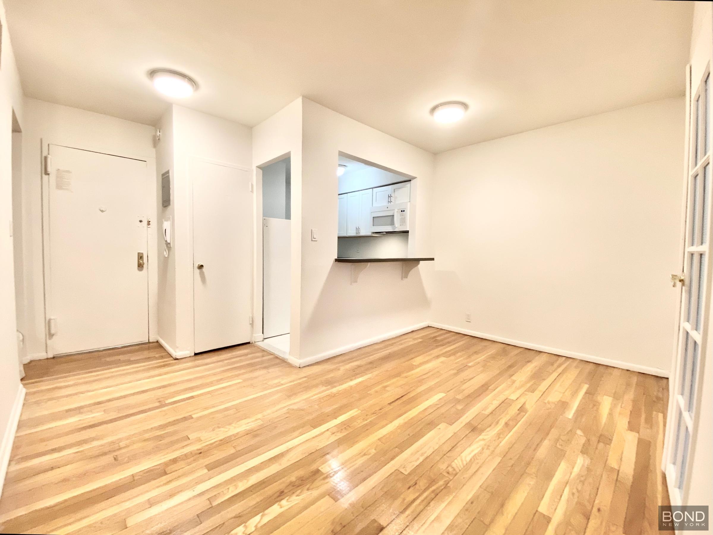 345 East 72nd Street, Unit 2A Manhattan, NY 10021 - Photo 2 of 10 a view of empty room with wooden floor and fan