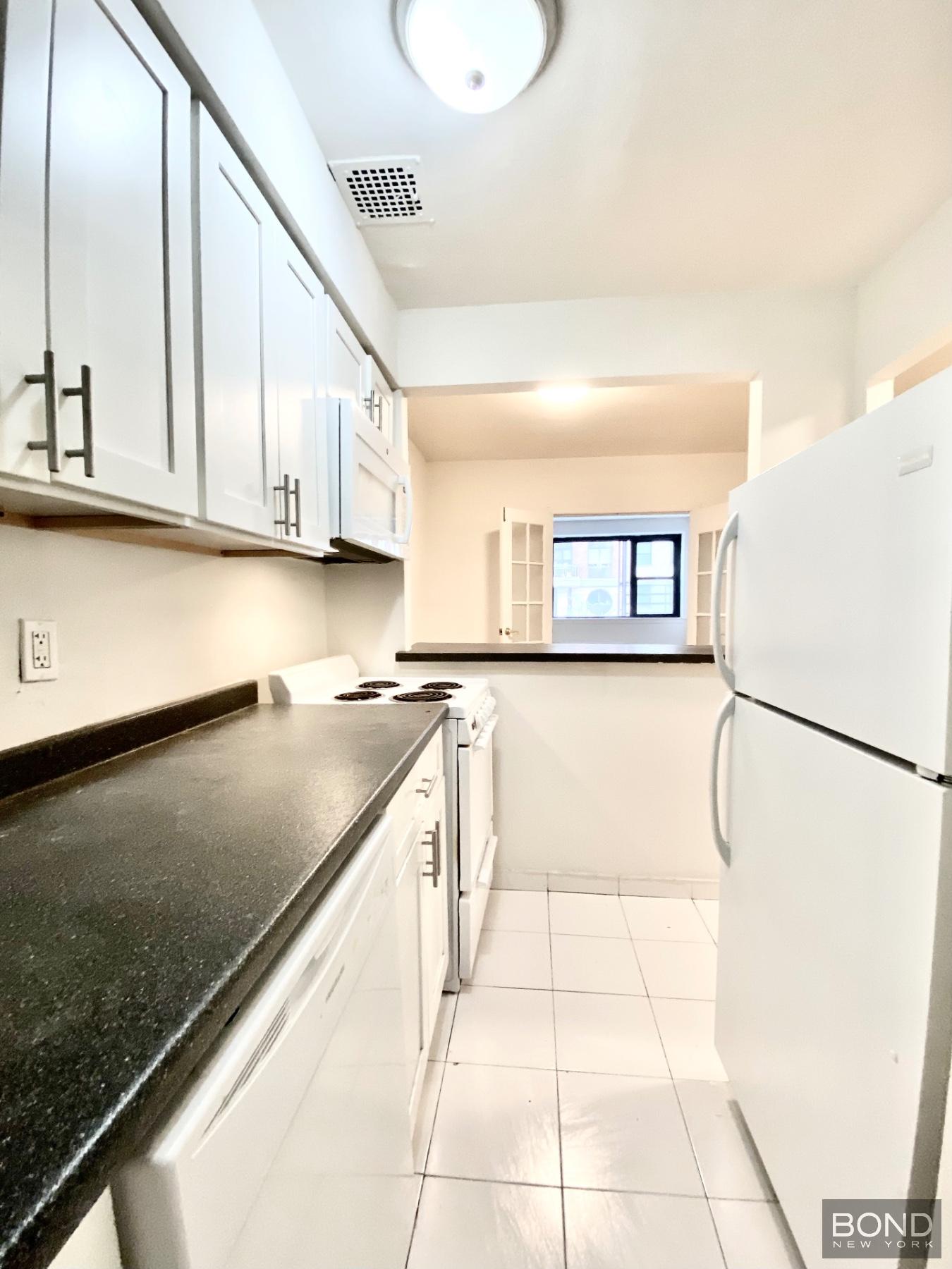 345 East 72nd Street, Unit 2A Manhattan, NY 10021 - Photo 3 of 10 a kitchen with a refrigerator a stove and a cabinets