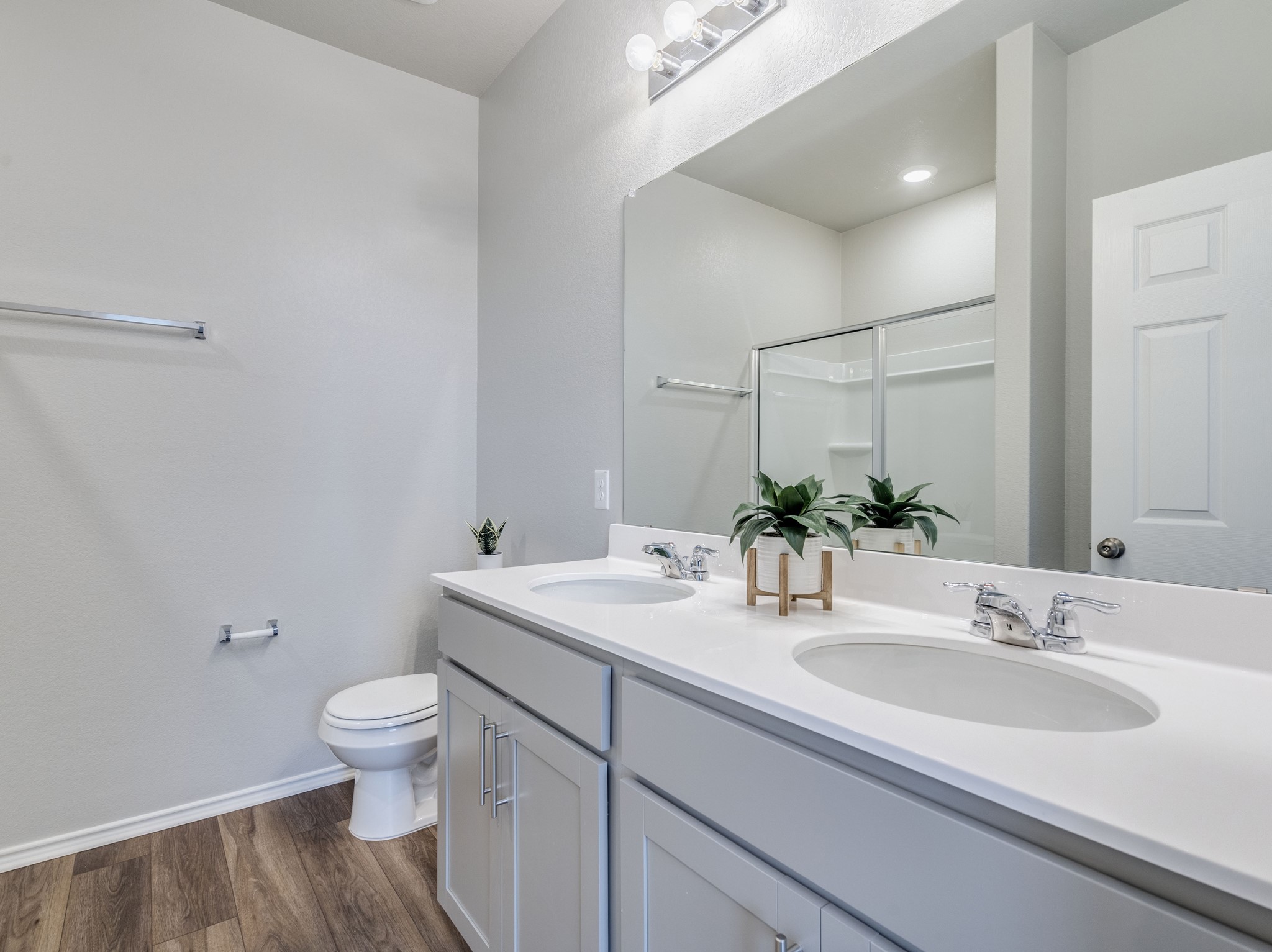 388 Begonia Street Buda, TX 78610 - Photo 13 of 21 Full bathroom featuring double vanity, a shower stall, and dark wood-style flooring