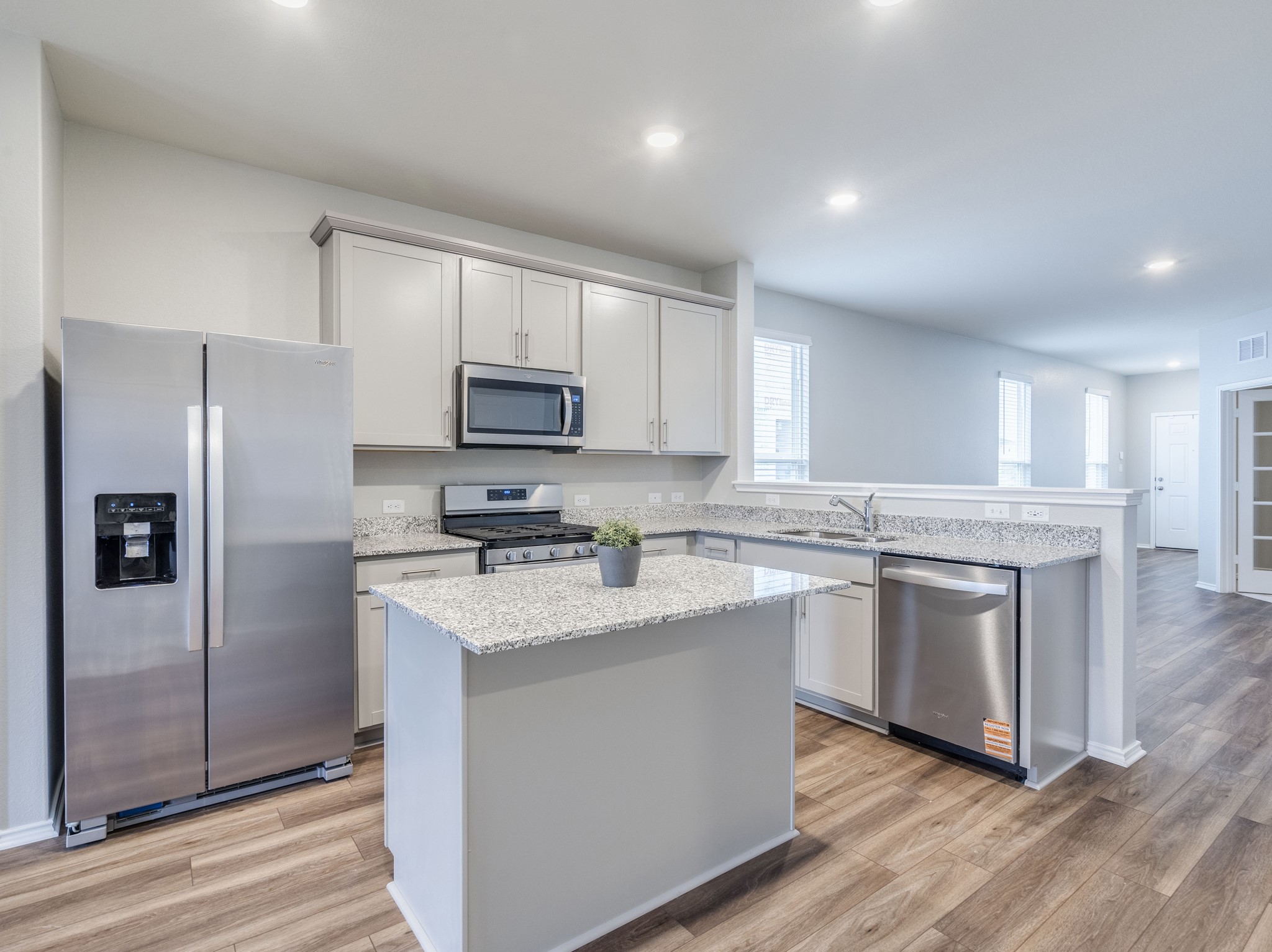 388 Begonia Street Buda, TX 78610 - Photo 8 of 21 Kitchen with stainless steel appliances, light stone counters, light wood-style flooring, recessed lighting, and a kitchen island