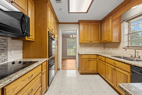 a large kitchen with stainless steel appliances granite countertop a sink and a stove
