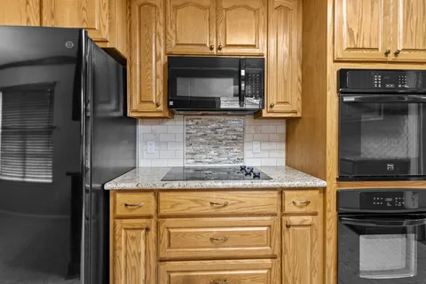 a kitchen with granite countertop a stove and a microwave