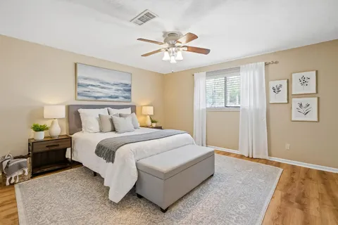 a spacious bedroom with a bed and a chandelier