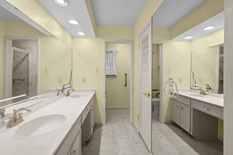 a spacious bathroom with a double vanity sink mirror and shower