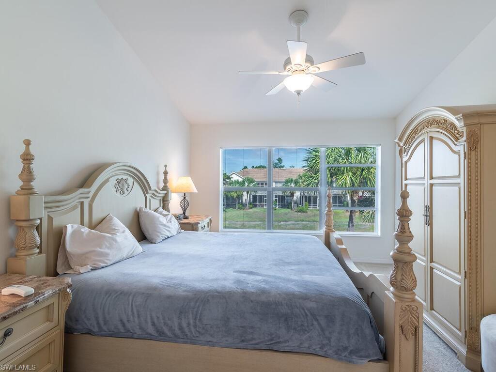 953 Hampton Circle, Unit 112 Naples, FL 34105 - Photo 17 of 35 a bedroom with a bed and a large window