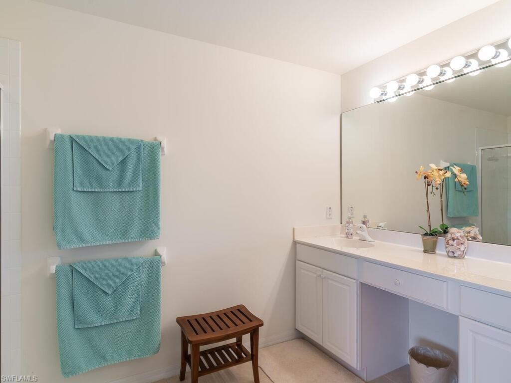953 Hampton Circle, Unit 112 Naples, FL 34105 - Photo 19 of 35 a bathroom with a sink a toilet and mirror