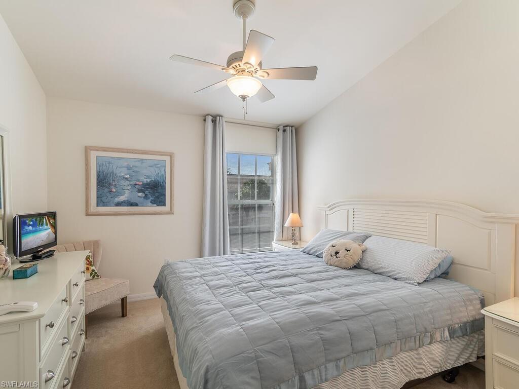 953 Hampton Circle, Unit 112 Naples, FL 34105 - Photo 22 of 35 a bedroom with a bed and a large window
