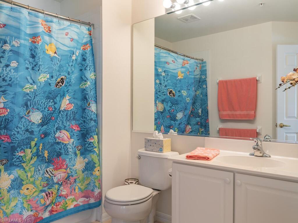953 Hampton Circle, Unit 112 Naples, FL 34105 - Photo 23 of 35 a bathroom with a sink mirror vanity and toilet