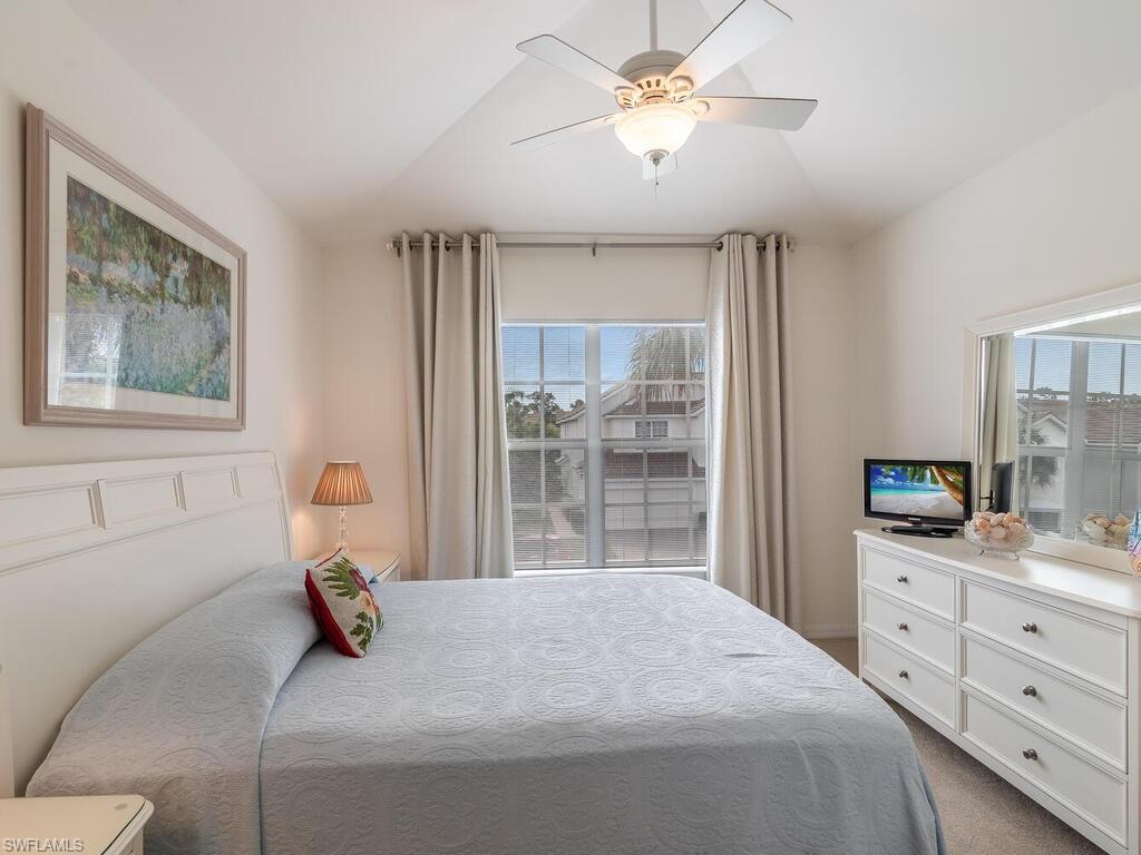 953 Hampton Circle, Unit 112 Naples, FL 34105 - Photo 24 of 35 a bedroom with a bed and a chandelier