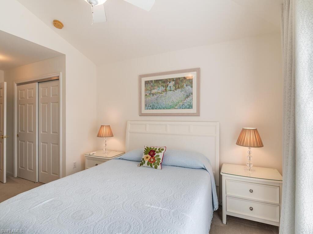 953 Hampton Circle, Unit 112 Naples, FL 34105 - Photo 25 of 35 a bedroom with a bed and a closet
