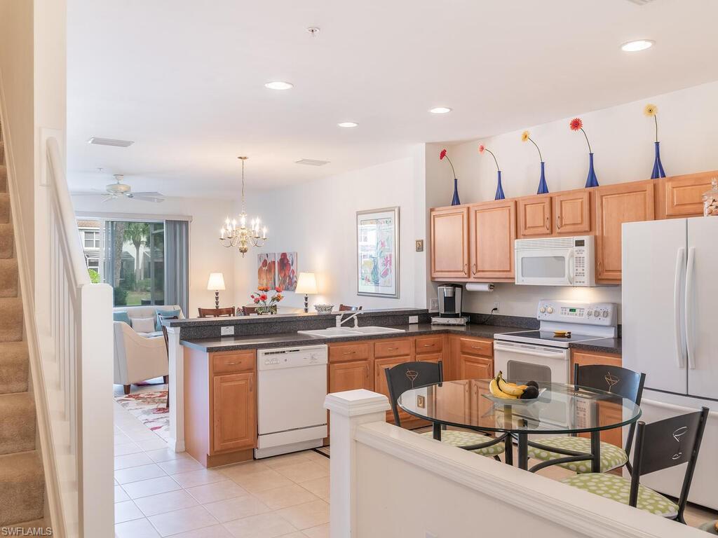 953 Hampton Circle, Unit 112 Naples, FL 34105 - Photo 4 of 35 a kitchen with stainless steel appliances kitchen island granite countertop a sink and cabinets
