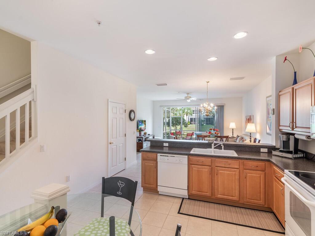 953 Hampton Circle, Unit 112 Naples, FL 34105 - Photo 6 of 35 a kitchen with stainless steel appliances granite countertop a stove a sink a refrigerator and cabinets