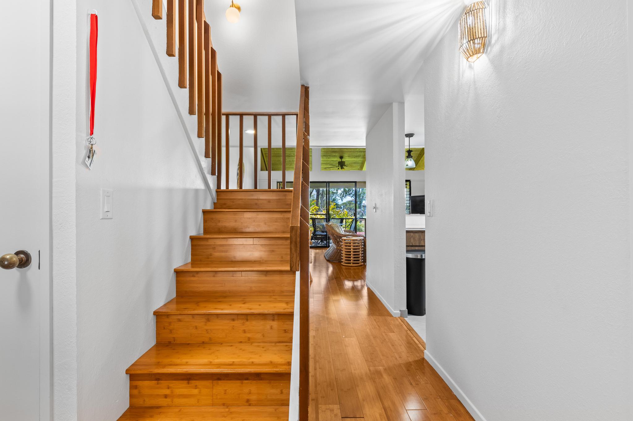 68-3840 Lua Kula Street, Unit F203 Waikoloa, HI 96738 - Photo 11 of 29 a view of staircase with lots of frames on wall and a wooden floor