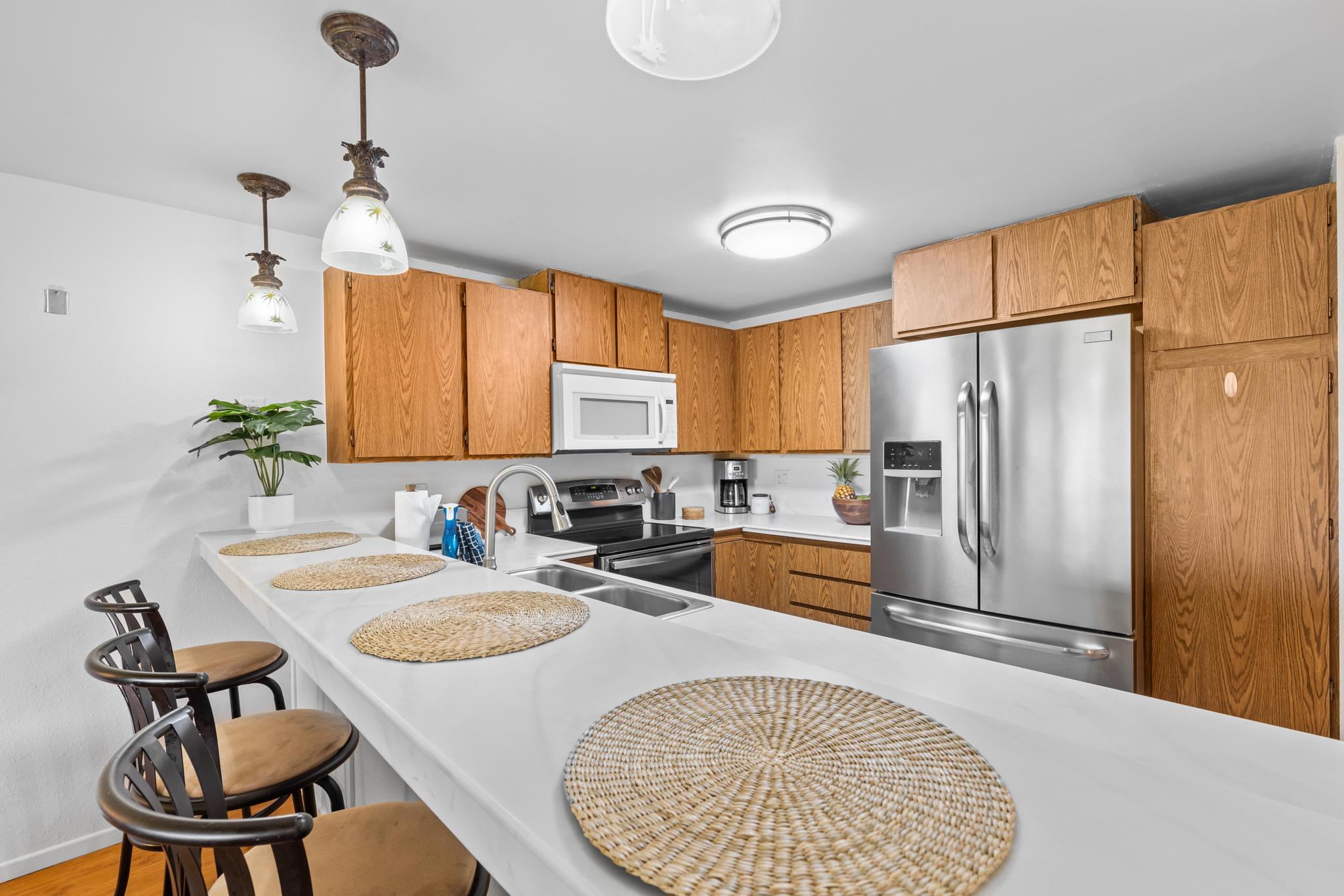 68-3840 Lua Kula Street, Unit F203 Waikoloa, HI 96738 - Photo 7 of 29 a kitchen with refrigerator and chairs