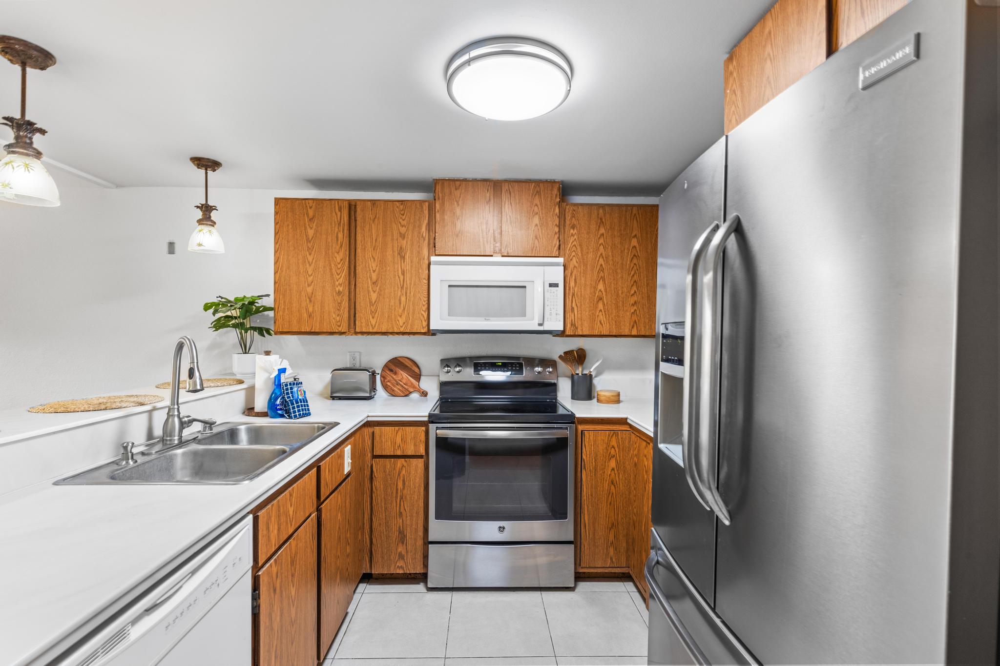 68-3840 Lua Kula Street, Unit F203 Waikoloa, HI 96738 - Photo 8 of 29 a kitchen with stainless steel appliances granite countertop a sink stove and refrigerator