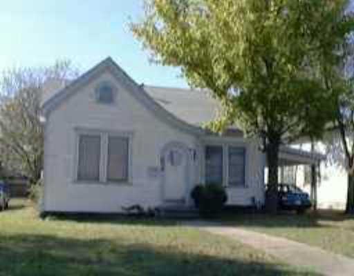a front view of a house with a garden and yard