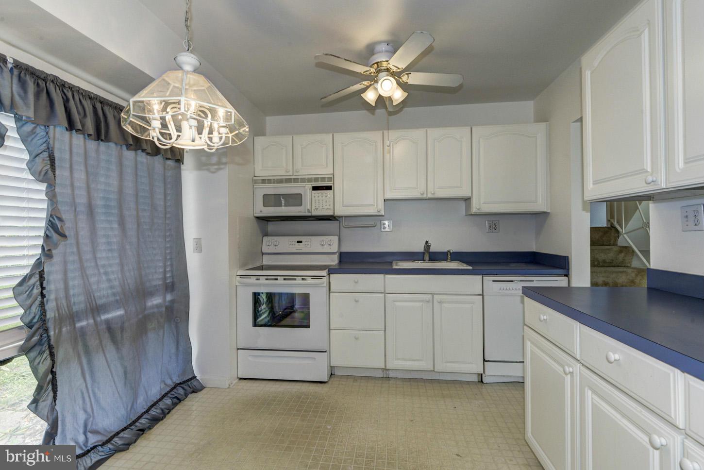 12515 Barbara Road Silver Spring, MD 20906 - Photo 3 of 8 a kitchen with stainless steel appliances granite countertop a stove a sink dishwasher a refrigerator and a dining table with wooden floor