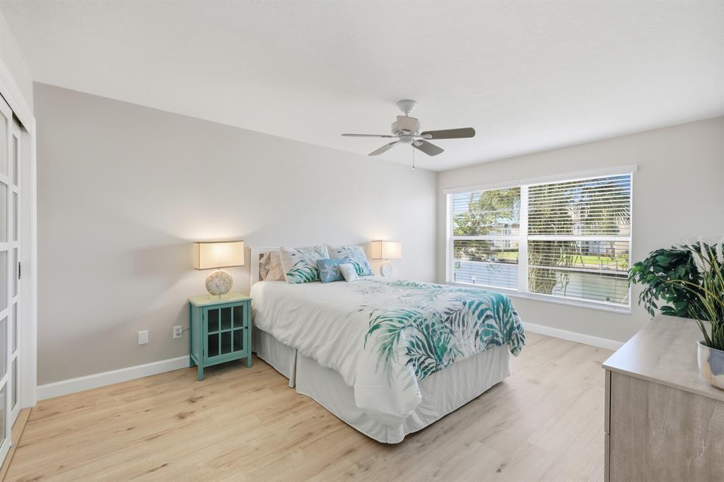 4380 Exeter Drive, Unit H202 Longboat Key, FL 34228 - Photo 15 of 37 a bedroom with a large bed and a chandelier