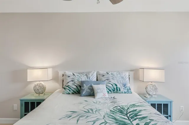 a spacious bedroom with a large bed a chandelier and windows