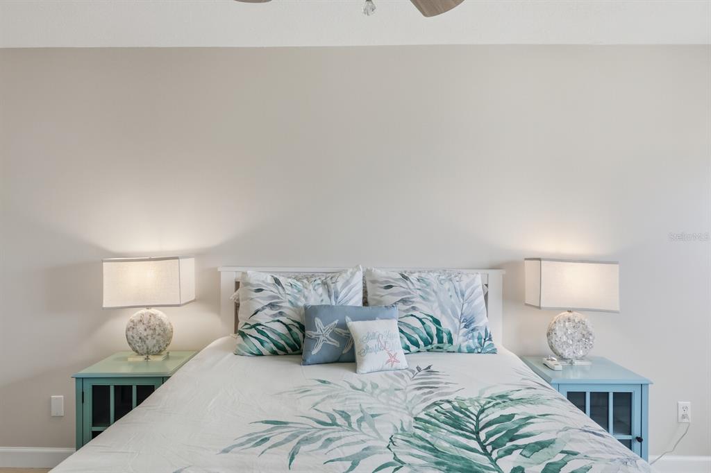 4380 Exeter Drive, Unit H202 Longboat Key, FL 34228 - Photo 16 of 37 a bedroom with a bed and lamp