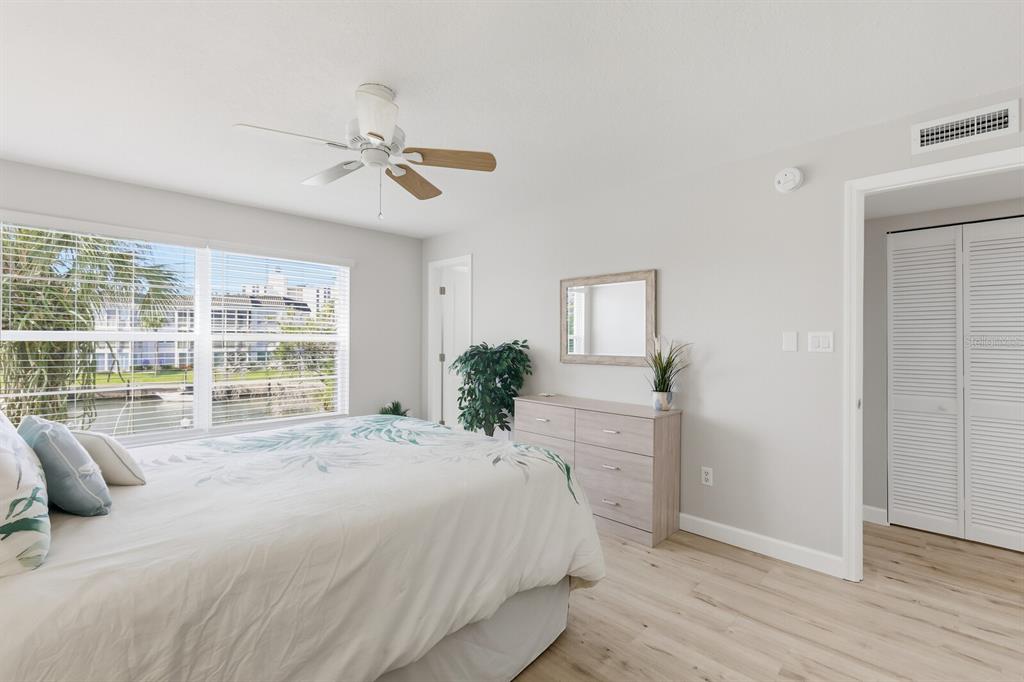4380 Exeter Drive, Unit H202 Longboat Key, FL 34228 - Photo 17 of 37 a spacious bedroom with a large bed a chandelier and windows