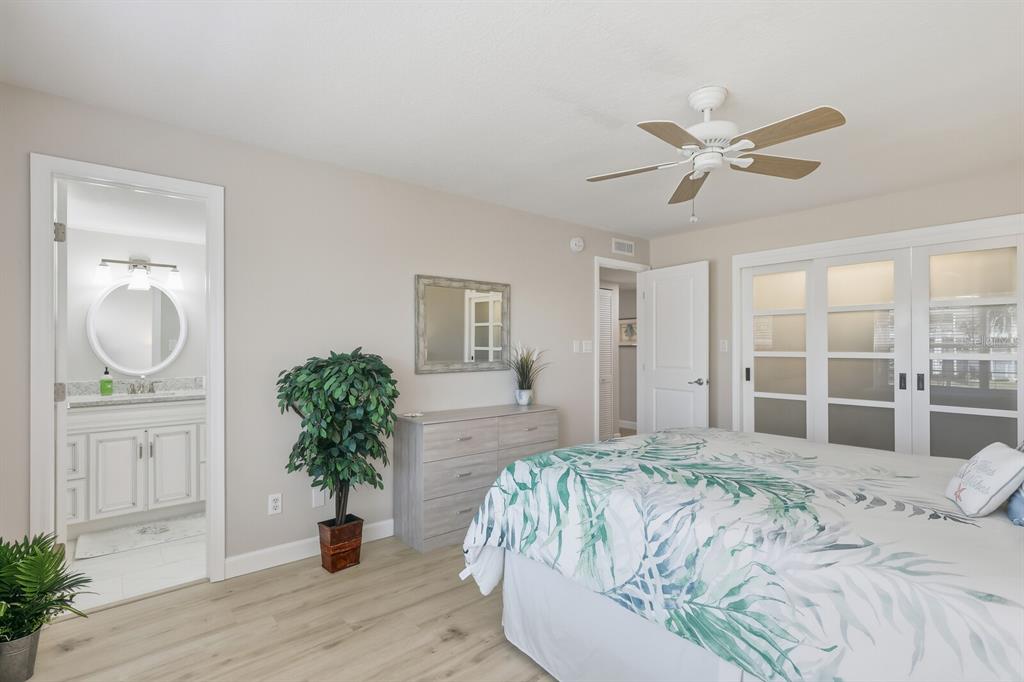 4380 Exeter Drive, Unit H202 Longboat Key, FL 34228 - Photo 18 of 37 a bedroom with a large bed and a chandelier
