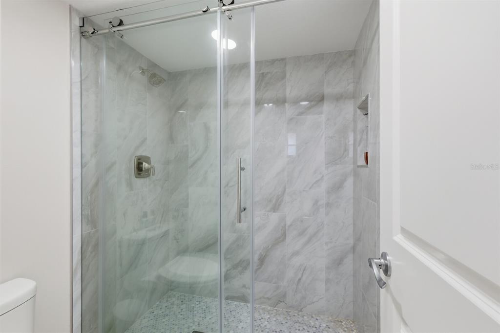 4380 Exeter Drive, Unit H202 Longboat Key, FL 34228 - Photo 21 of 37 a bathroom with a shower and toilet