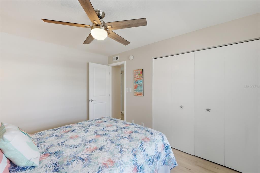 4380 Exeter Drive, Unit H202 Longboat Key, FL 34228 - Photo 23 of 37 a bedroom with a bed and a chandelier fan