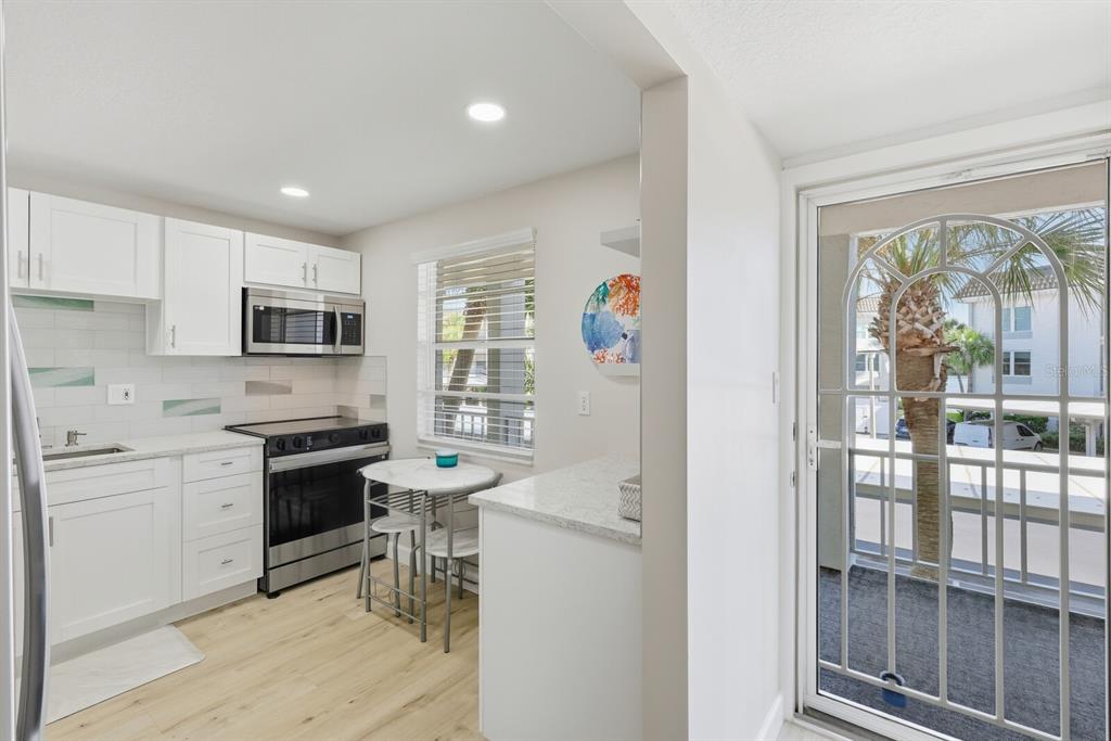 4380 Exeter Drive, Unit H202 Longboat Key, FL 34228 - Photo 25 of 37 a kitchen with granite countertop stainless steel appliances a stove top oven and a refrigerator