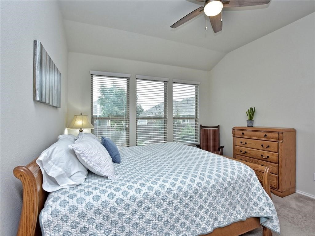 305 Methodius Drive Hutto, TX 78634 - Photo 13 of 26 a bedroom with a bed and a dresser