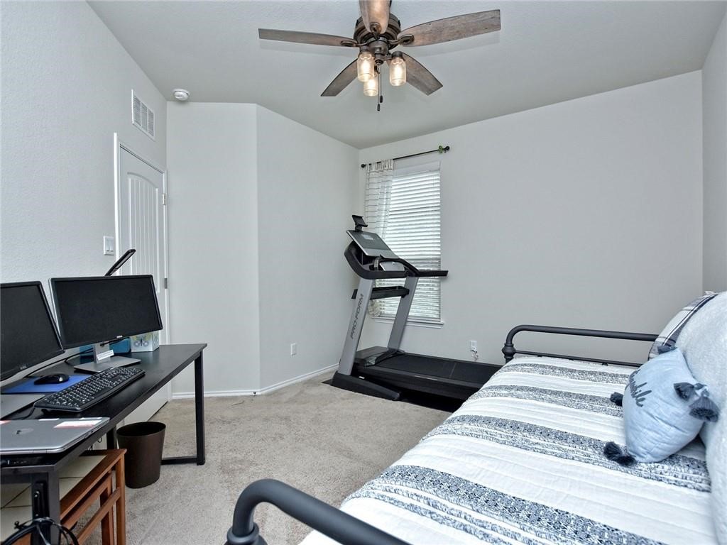305 Methodius Drive Hutto, TX 78634 - Photo 17 of 26 a bedroom with a bed and a computer on the desk