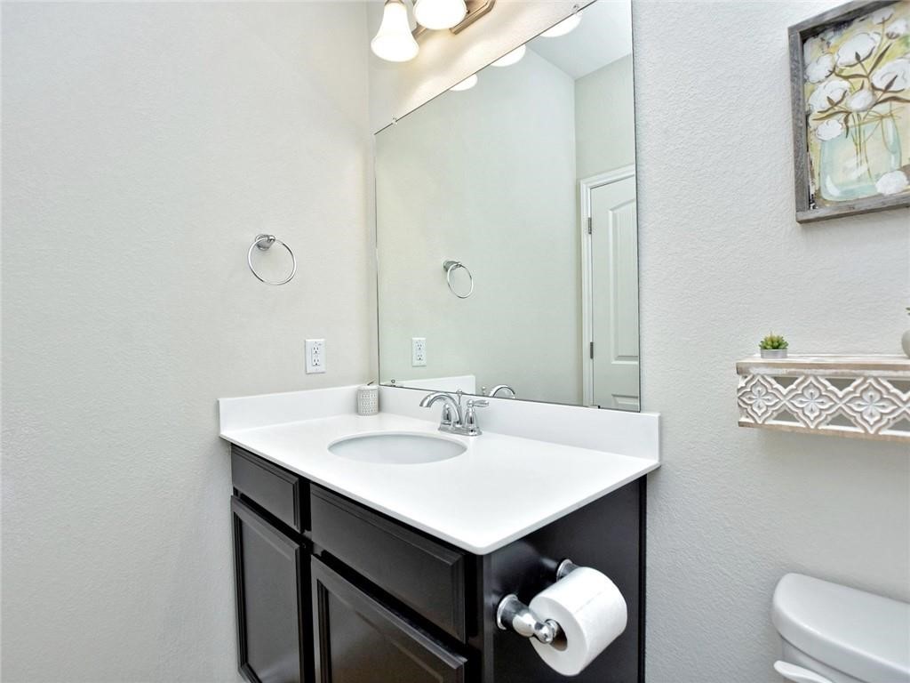 305 Methodius Drive Hutto, TX 78634 - Photo 18 of 26 a bathroom with a sink vanity and a mirror