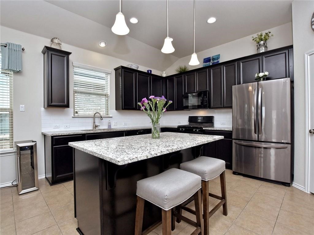 305 Methodius Drive Hutto, TX 78634 - Photo 3 of 26 a kitchen with cabinets and stainless steel appliances