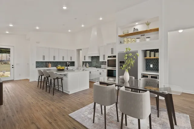 a kitchen with stainless steel appliances kitchen island granite countertop a table and chairs in it