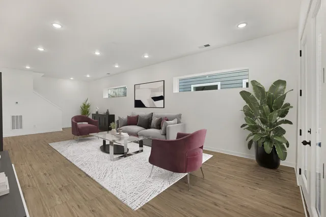 a living room with furniture potted plant and a wooden floor