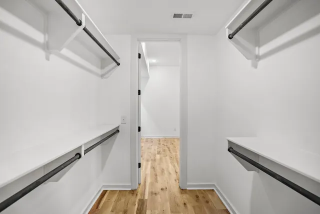 a view of walk in closet with wooden floor