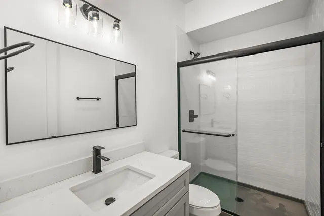 a bathroom with a sink a toilet and shower