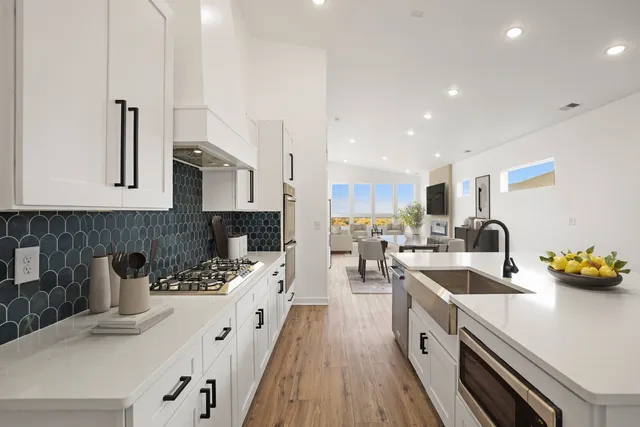 a kitchen with stainless steel appliances a sink a stove and a wooden floors