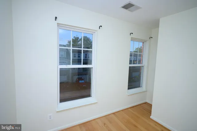 a view of a hallway with wooden floor and a window