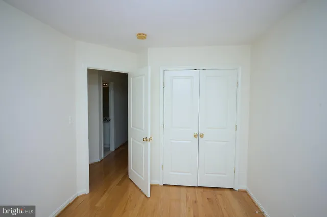 an empty room with wooden floor and closet