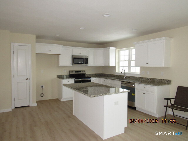 73 Warm Earth Road Naugatuck, CT 06770 - Photo 5 of 24 a kitchen with granite countertop white cabinets and white appliances