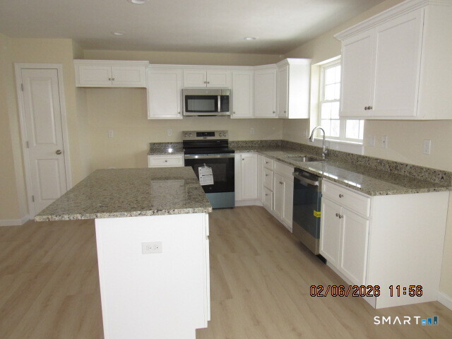 73 Warm Earth Road Naugatuck, CT 06770 - Photo 6 of 24 a kitchen with granite countertop a sink a stove top oven and cabinetry