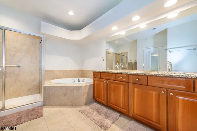 a spacious bathroom with a tub sink shower and mirror