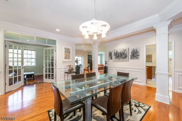 a dining room with wooden floor and large windows