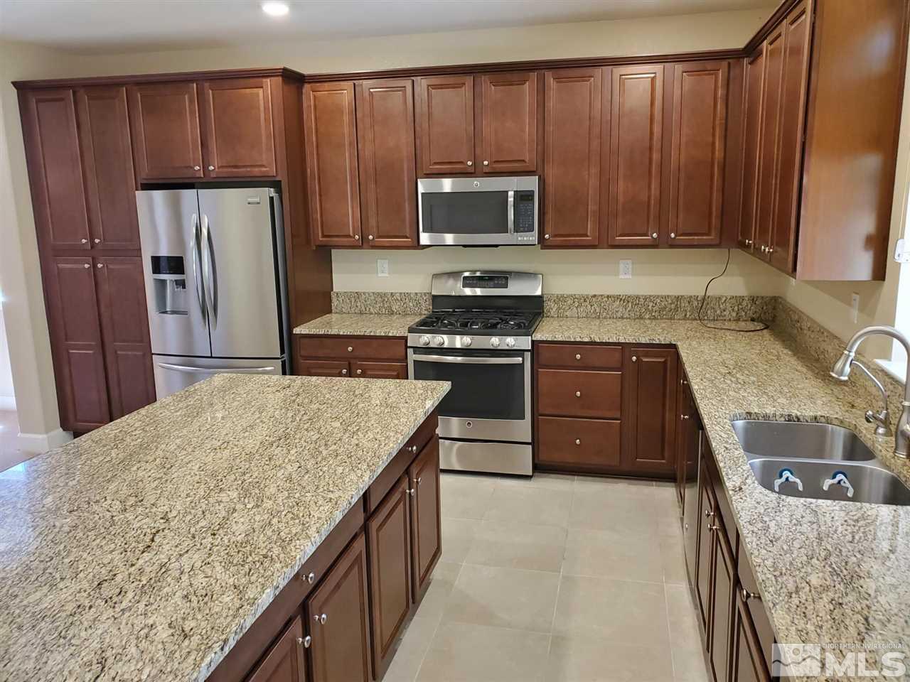 1655 Heavenly View Trail Reno, NV 89523 - Photo 4 of 39 a kitchen with stainless steel appliances granite countertop wooden cabinets a stove top oven a sink and dishwasher