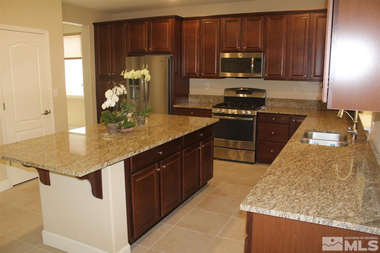 1655 Heavenly View Trail Reno, NV 89523 - Photo 5 of 39 a kitchen with stainless steel appliances granite countertop wooden cabinets a stove a sink and dishwasher