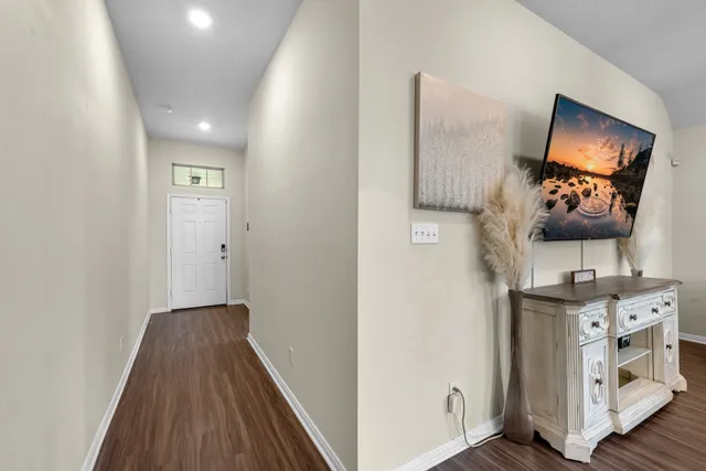 a bedroom with a bed and a flat tv screen on a dresser