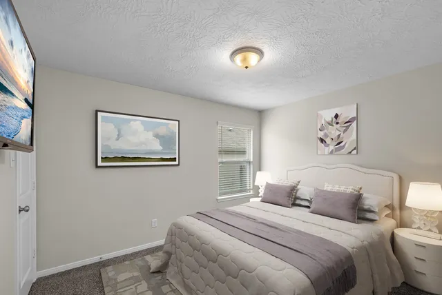 a bedroom with a bed and a painting on the wall