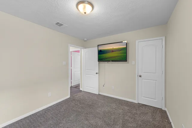 an empty room with window and wooden floor